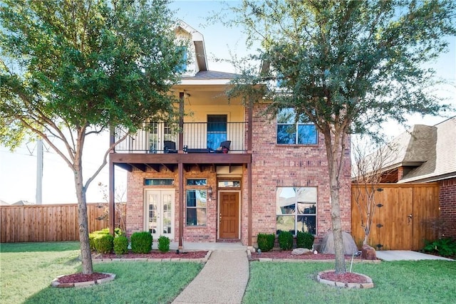 view of front of property featuring a front yard and a balcony