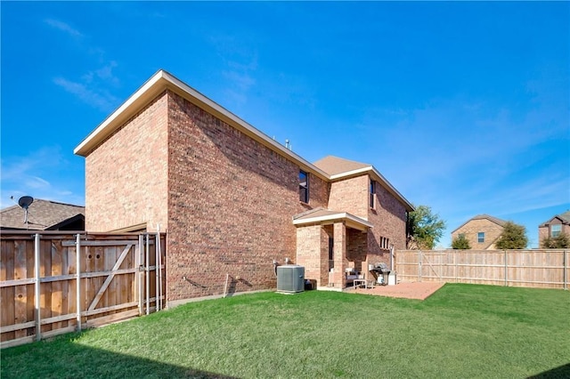 rear view of house featuring a patio, central AC unit, and a yard