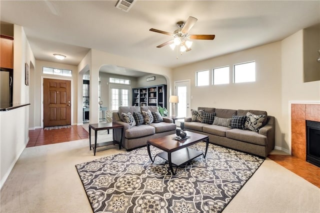 living room with tile patterned floors and a tiled fireplace