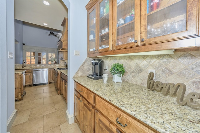 kitchen featuring sink, light stone counters, dishwasher, ceiling fan, and decorative backsplash