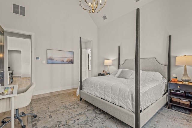 bedroom with light hardwood / wood-style flooring, a chandelier, and high vaulted ceiling