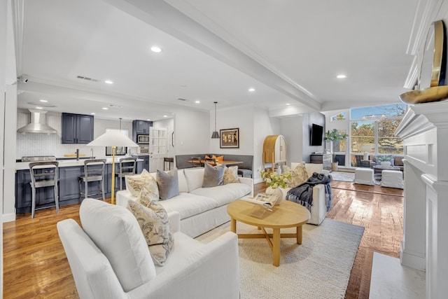 living room featuring beam ceiling and light hardwood / wood-style flooring