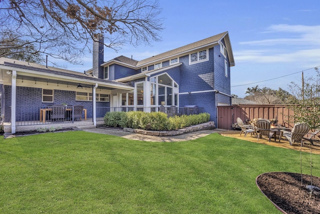 rear view of house featuring a lawn, an outdoor fire pit, and a patio