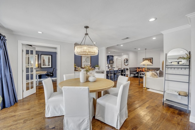 dining room featuring hardwood / wood-style flooring, crown molding, and a chandelier