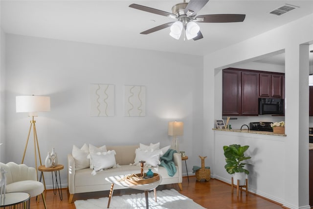 living room featuring dark hardwood / wood-style floors and ceiling fan