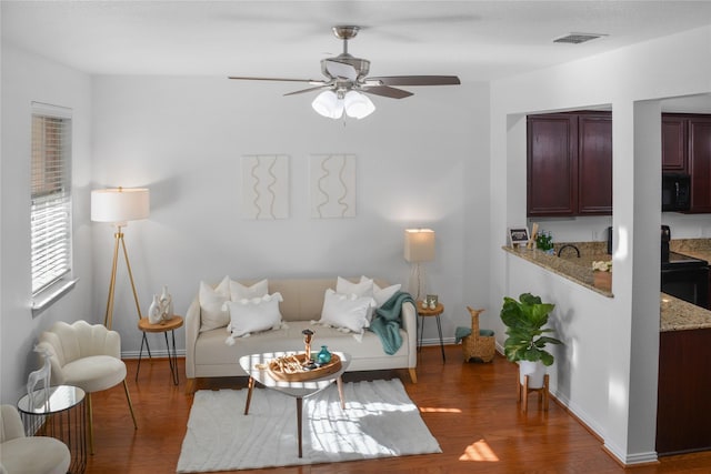 living room with dark wood-type flooring and ceiling fan