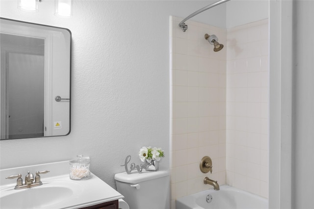 full bathroom featuring vanity, tiled shower / bath, and toilet