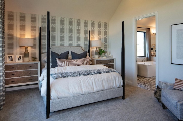 bedroom with carpet floors, vaulted ceiling, and ensuite bathroom