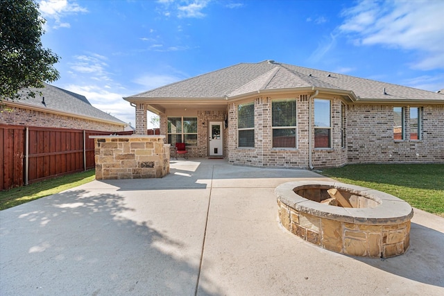 rear view of house featuring a patio area and a fire pit