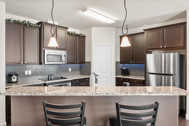 kitchen featuring appliances with stainless steel finishes, a kitchen island, and pendant lighting