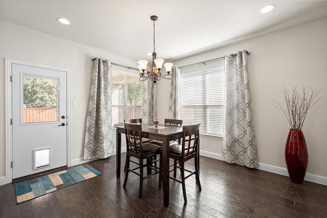 dining room featuring a wealth of natural light, a notable chandelier, and dark hardwood / wood-style flooring