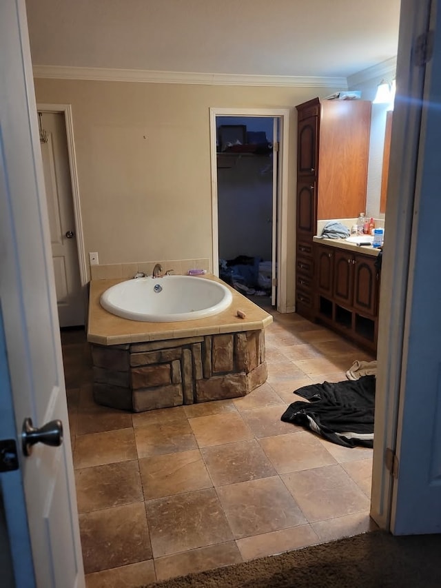 bathroom with tiled bath, vanity, and ornamental molding