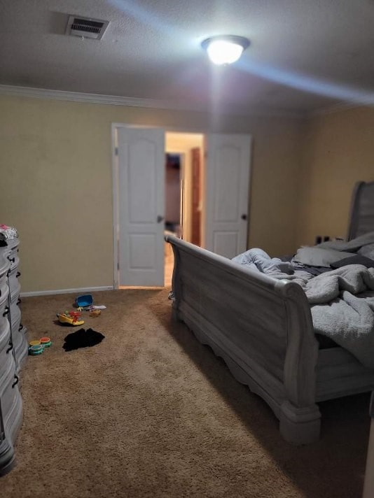 bedroom featuring ornamental molding and carpet flooring