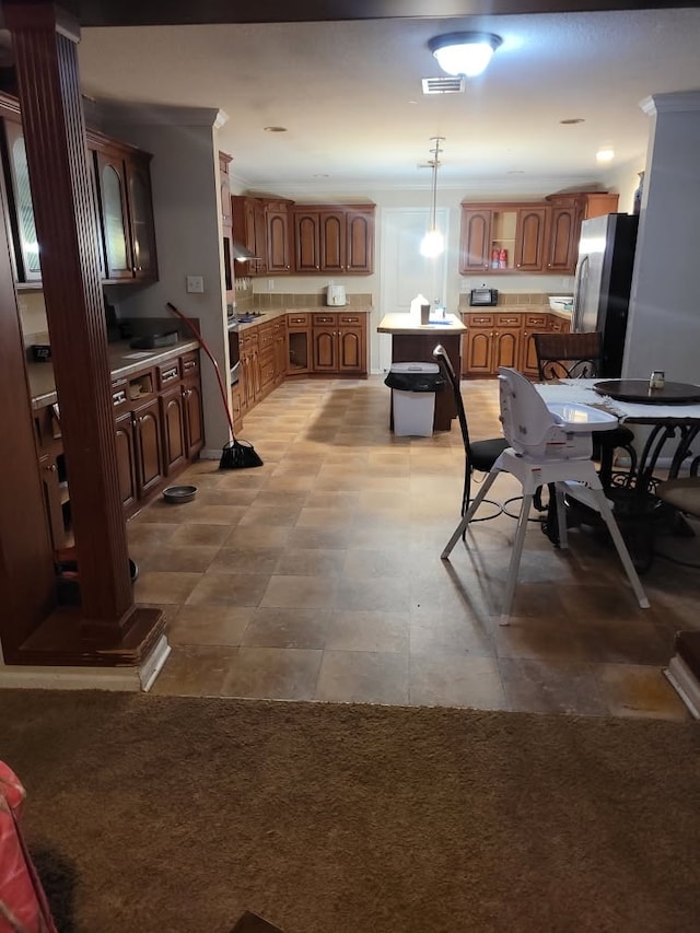 kitchen featuring pendant lighting, light carpet, stainless steel refrigerator, and a center island