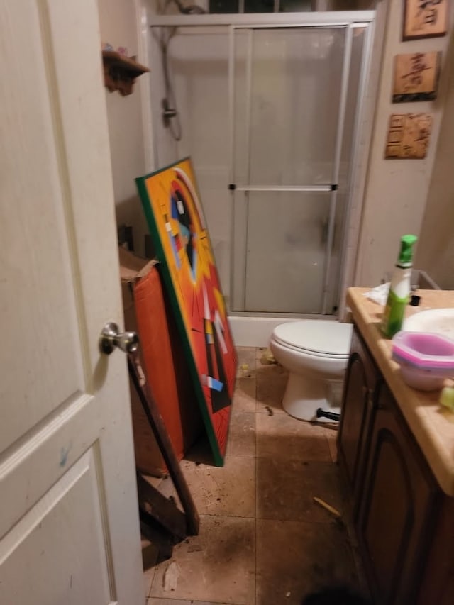 bathroom with vanity, a shower with door, and toilet