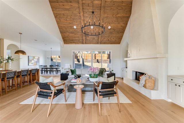 dining space with a large fireplace, high vaulted ceiling, light wood finished floors, and wood ceiling