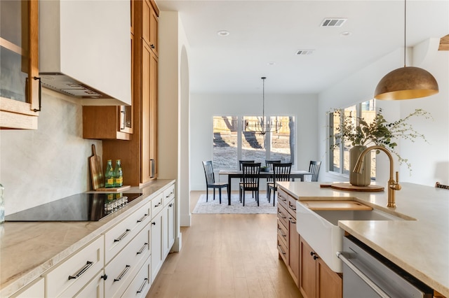 kitchen with hanging light fixtures, dishwasher, white cabinets, and light countertops