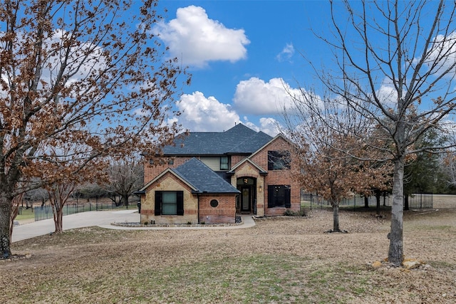 view of front of home featuring a shingled roof and brick siding