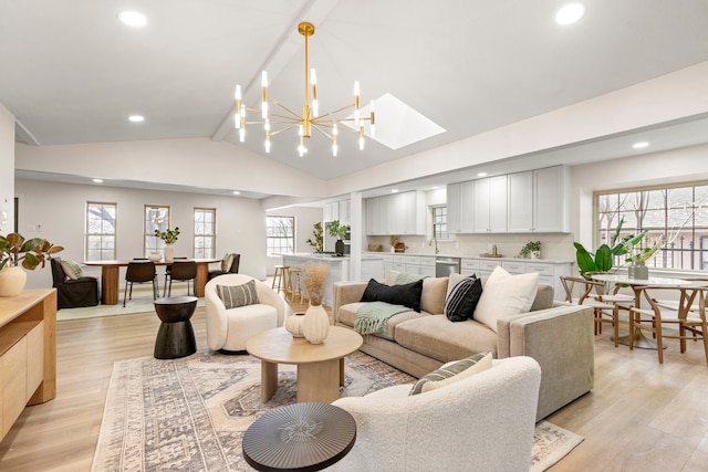 living room with vaulted ceiling, light wood finished floors, recessed lighting, and a notable chandelier