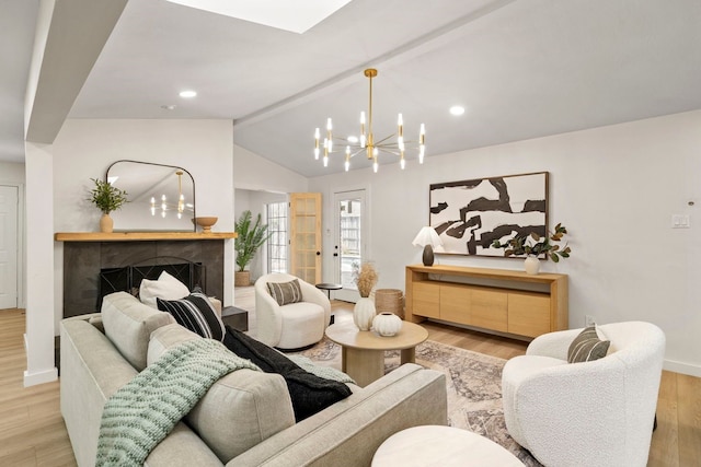 living area featuring baseboards, a tile fireplace, light wood-style flooring, vaulted ceiling with beams, and a notable chandelier