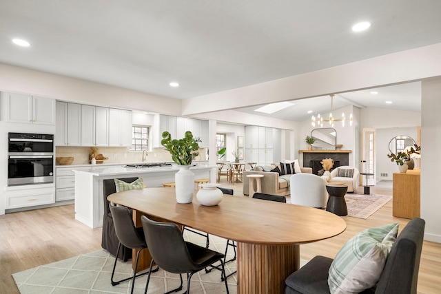 dining space with recessed lighting, vaulted ceiling, and light wood-style flooring