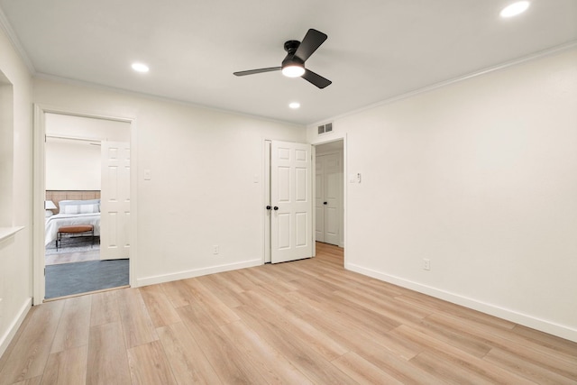 unfurnished bedroom with light wood-style floors, baseboards, visible vents, and crown molding