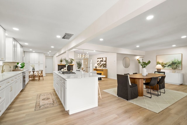 kitchen featuring light countertops, radiator, white cabinets, and a kitchen island