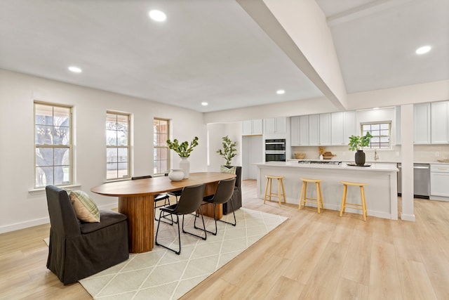 dining room with light wood-style floors, a wealth of natural light, and recessed lighting