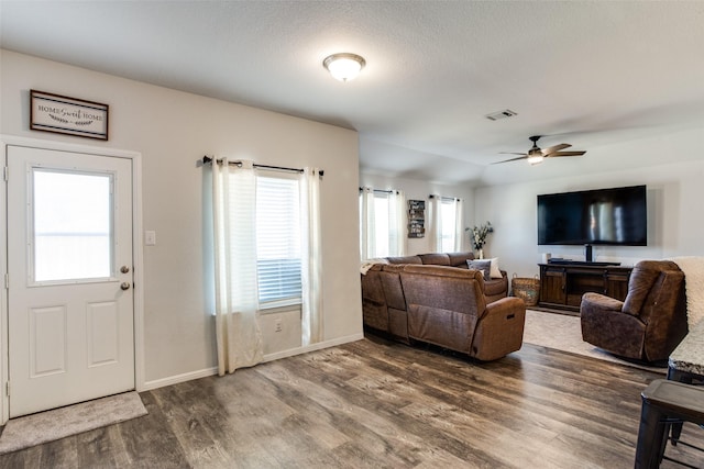 living room featuring hardwood / wood-style flooring, ceiling fan, and a textured ceiling