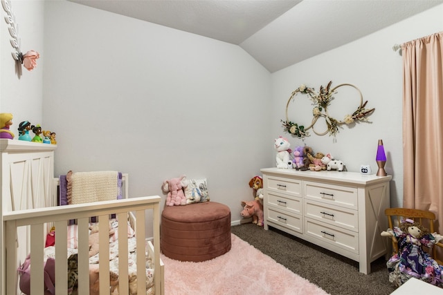 bedroom featuring dark carpet, a nursery area, and lofted ceiling