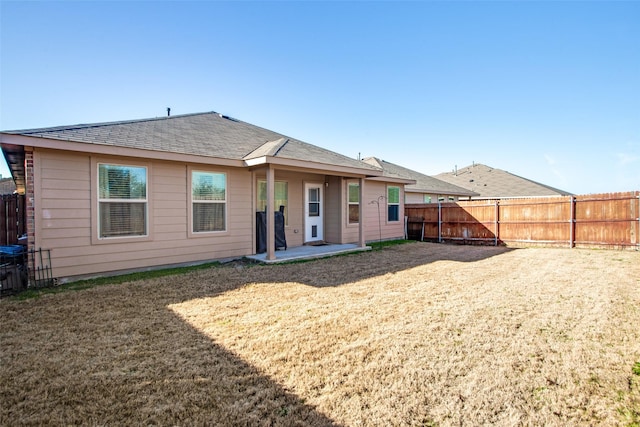 back of house with a patio and a lawn