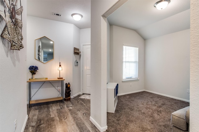 foyer featuring vaulted ceiling and dark hardwood / wood-style flooring