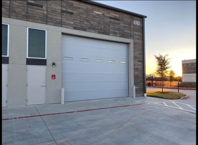 view of garage at dusk