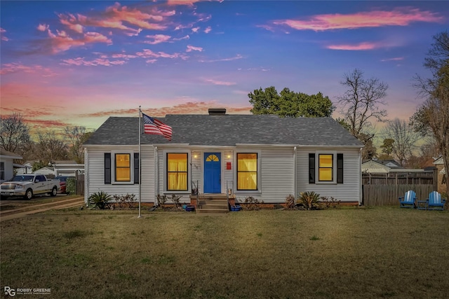 single story home featuring fence and a lawn