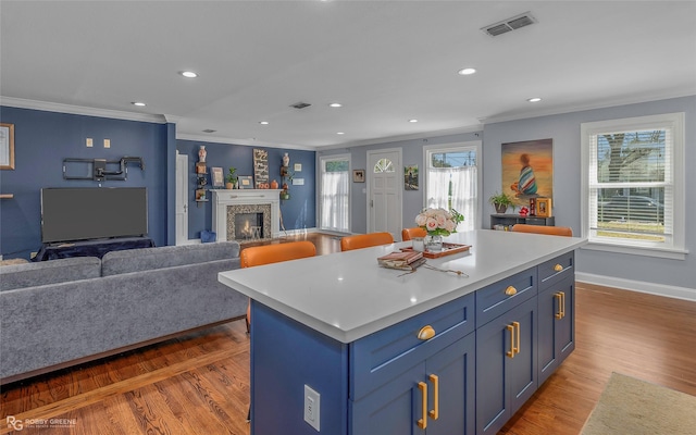 kitchen featuring visible vents, wood finished floors, and open floor plan