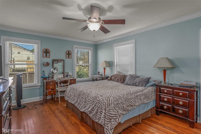 bedroom with crown molding, multiple windows, and wood finished floors