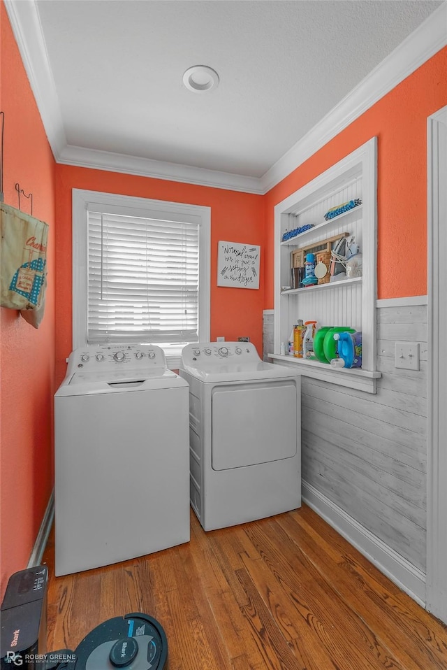 laundry room featuring ornamental molding, washer and dryer, built in features, wood finished floors, and laundry area