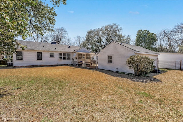 rear view of property with a yard and fence