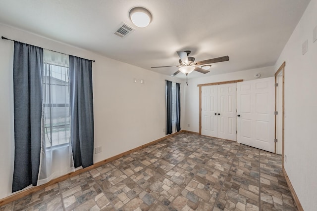 unfurnished bedroom featuring a closet, visible vents, ceiling fan, and baseboards