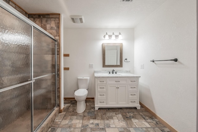 bathroom featuring a stall shower, visible vents, baseboards, stone finish flooring, and vanity