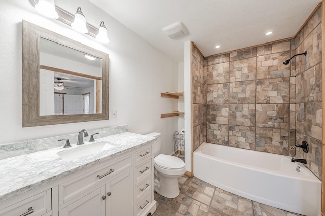 bathroom with bathtub / shower combination, toilet, recessed lighting, vanity, and stone finish flooring