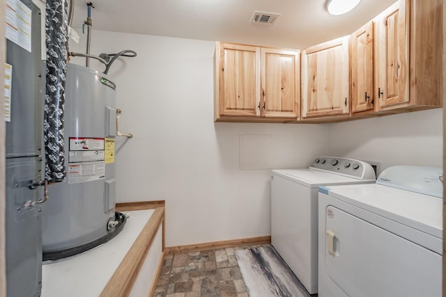 laundry area featuring visible vents, cabinet space, electric water heater, washer and dryer, and baseboards