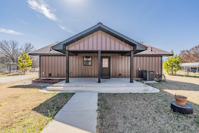 view of front of home with central AC, metal roof, and board and batten siding