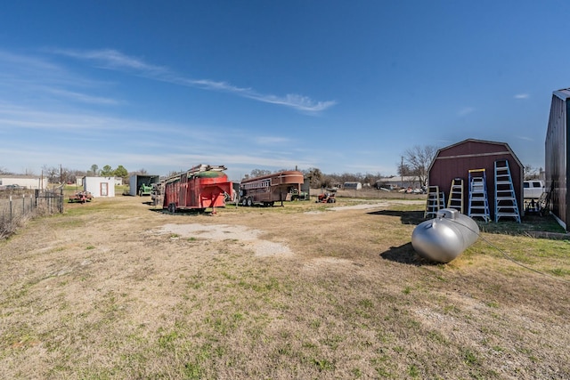 view of yard with an outbuilding, fence, and a barn