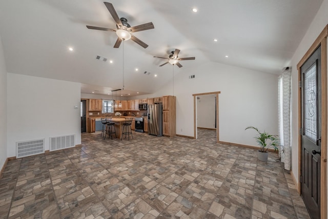 kitchen with a kitchen island, visible vents, a kitchen breakfast bar, and appliances with stainless steel finishes