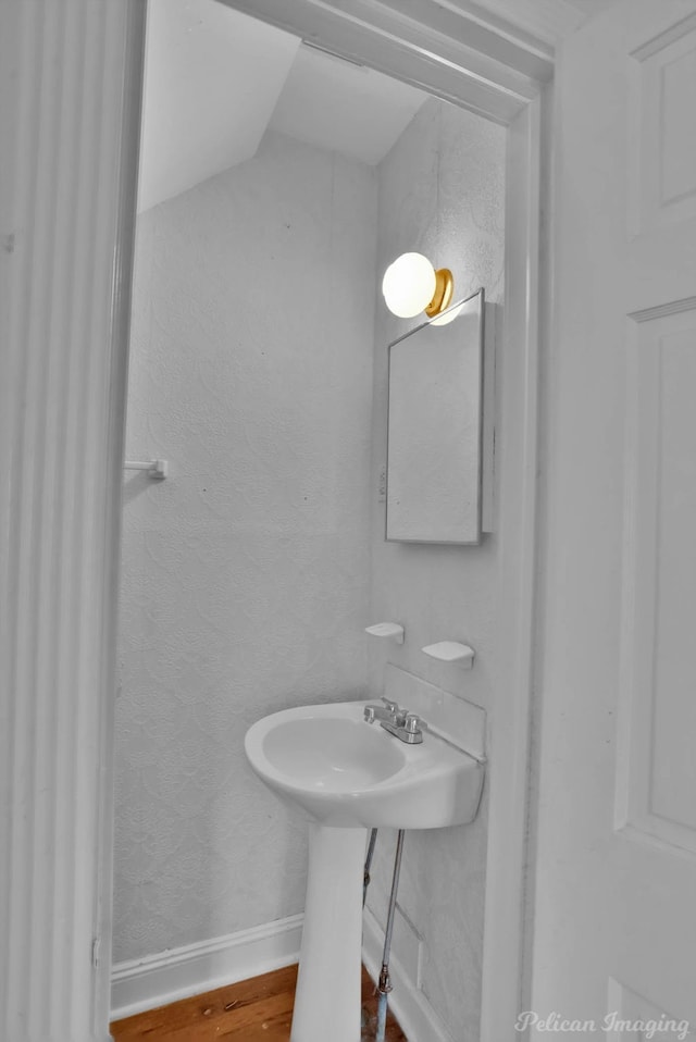 bathroom featuring a sink, baseboards, and wood finished floors