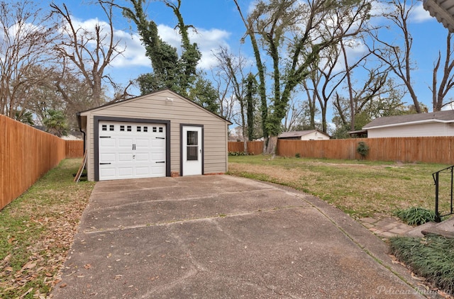 detached garage with concrete driveway and fence