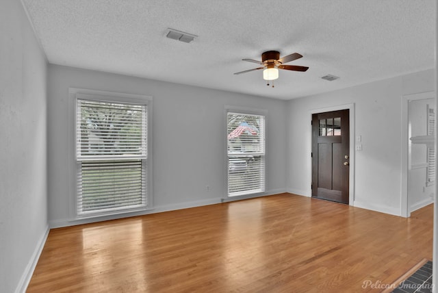 interior space featuring ceiling fan, baseboards, visible vents, and light wood-type flooring