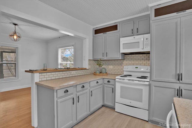 kitchen with light wood-style flooring, ornamental molding, white appliances, a peninsula, and light countertops