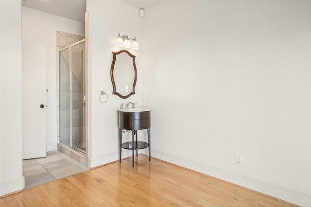 bathroom featuring a shower with door and hardwood / wood-style floors